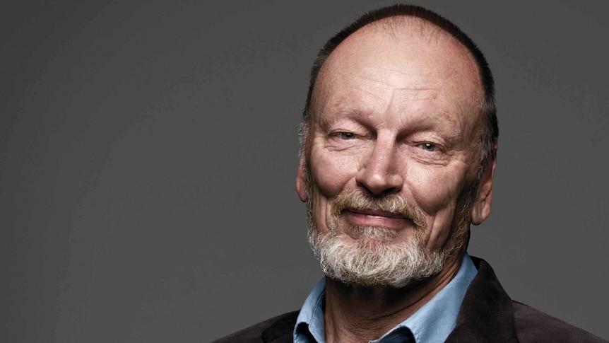 Head and shoulders portrait of an older man in a collared blue shirt