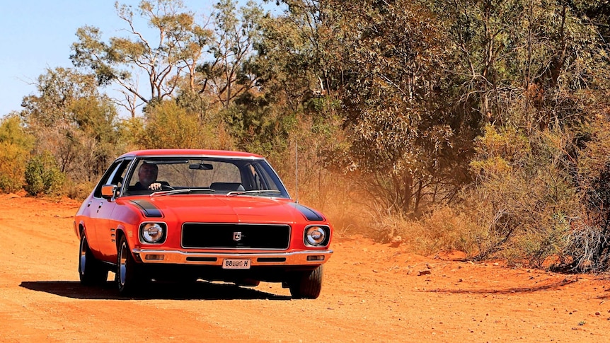 Old red Holden on dirt road