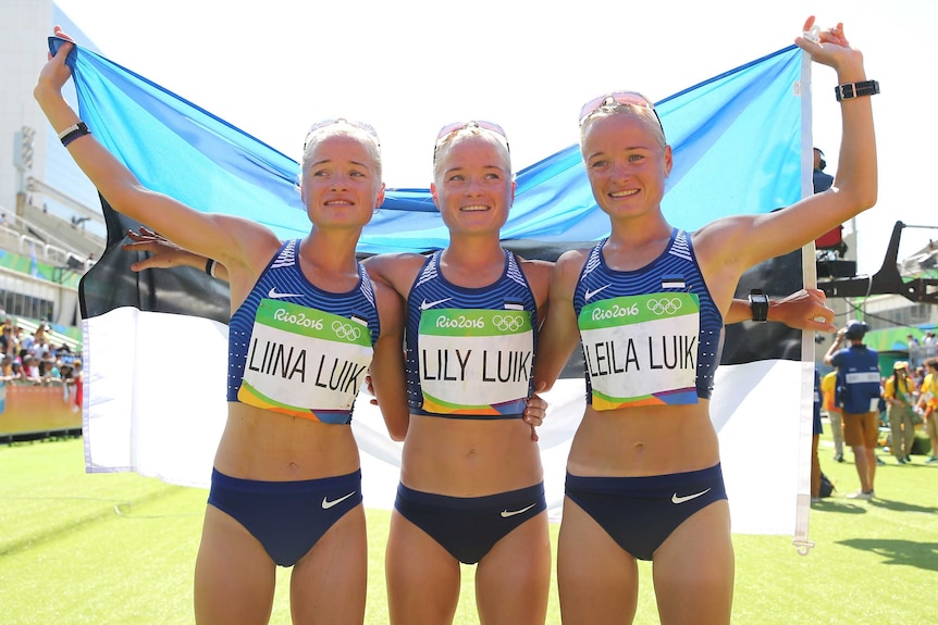 The Luik sisters hold the Estonian flag after the marathon in which they all competed