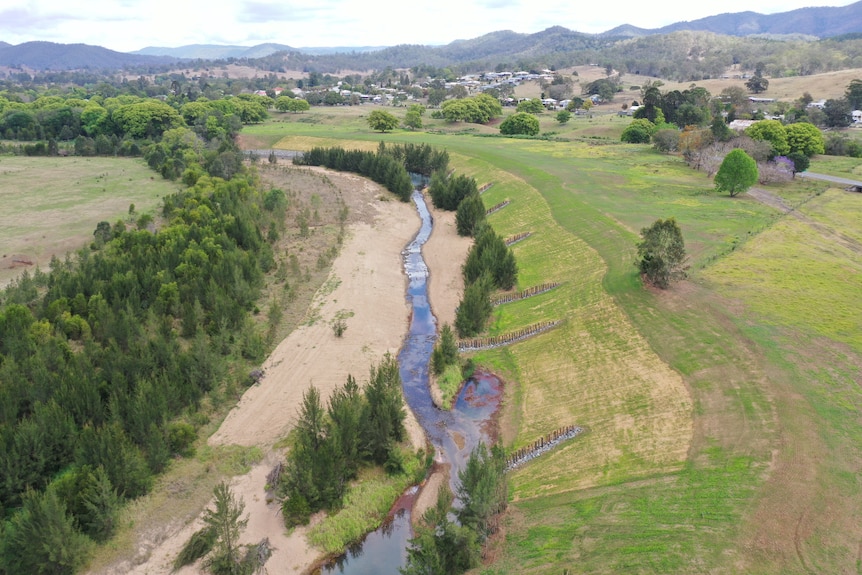 Thin stream of water in wide river bed.