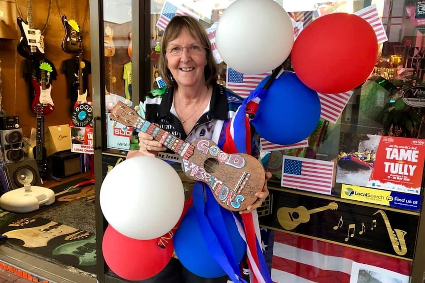 Business owner in shopfront with flag