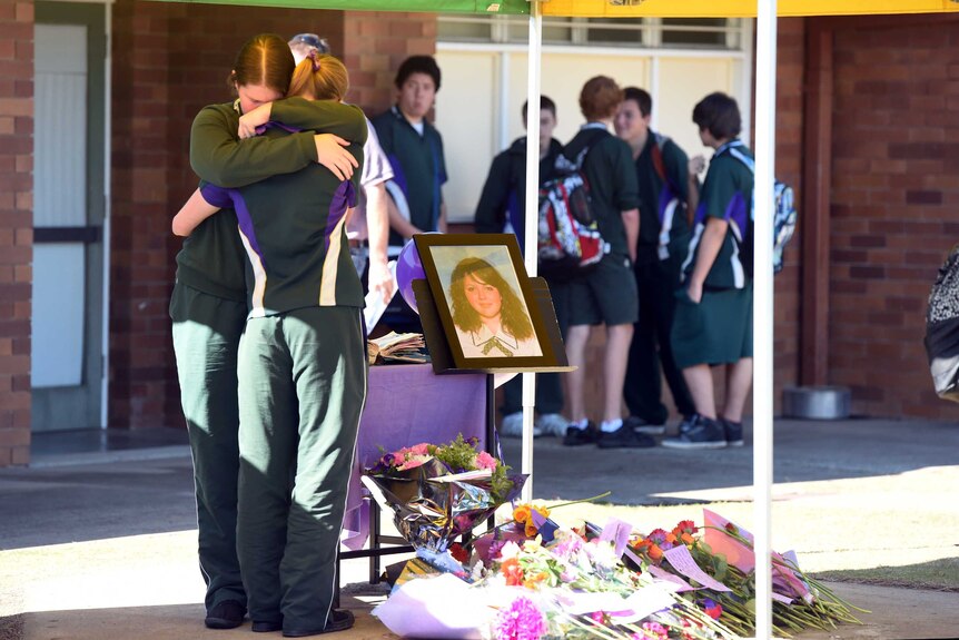 Students comfort each other near a shrine for murdered teenager Jayde Kendall