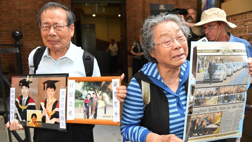 Feng Qing Zhu and Yang Fei Lin cry and hold up photos of their murdered grandchildren outside the NSW Supreme Court.
