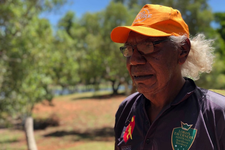 Ross Jakamarra Williams wears glasses and a yellow cap