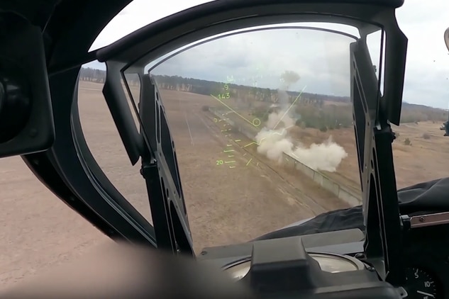 A puff of smoke can be seen through the window of a helicopter