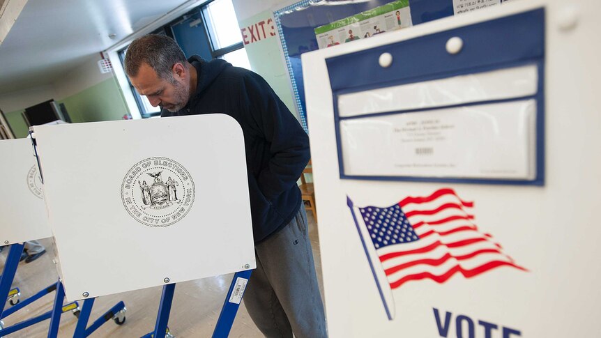 Man votes at a booth in the United States
