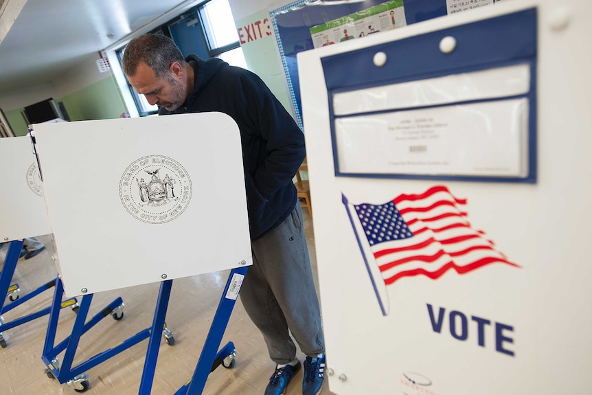 Man votes at a booth in the United States