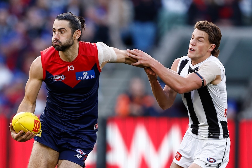 Brodie Grundy is tackled by the arm by Pat Lipinski