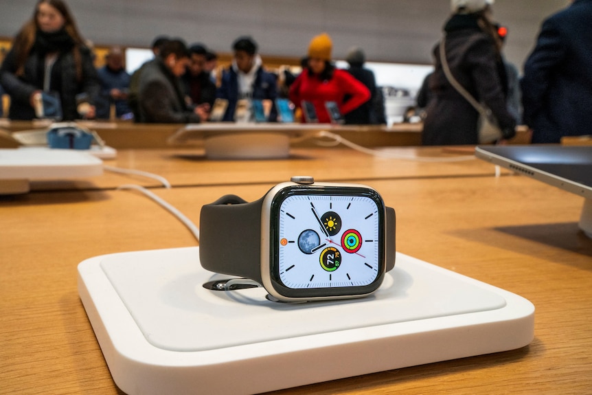 apple watch sits on a charging wireless pad at the apple store