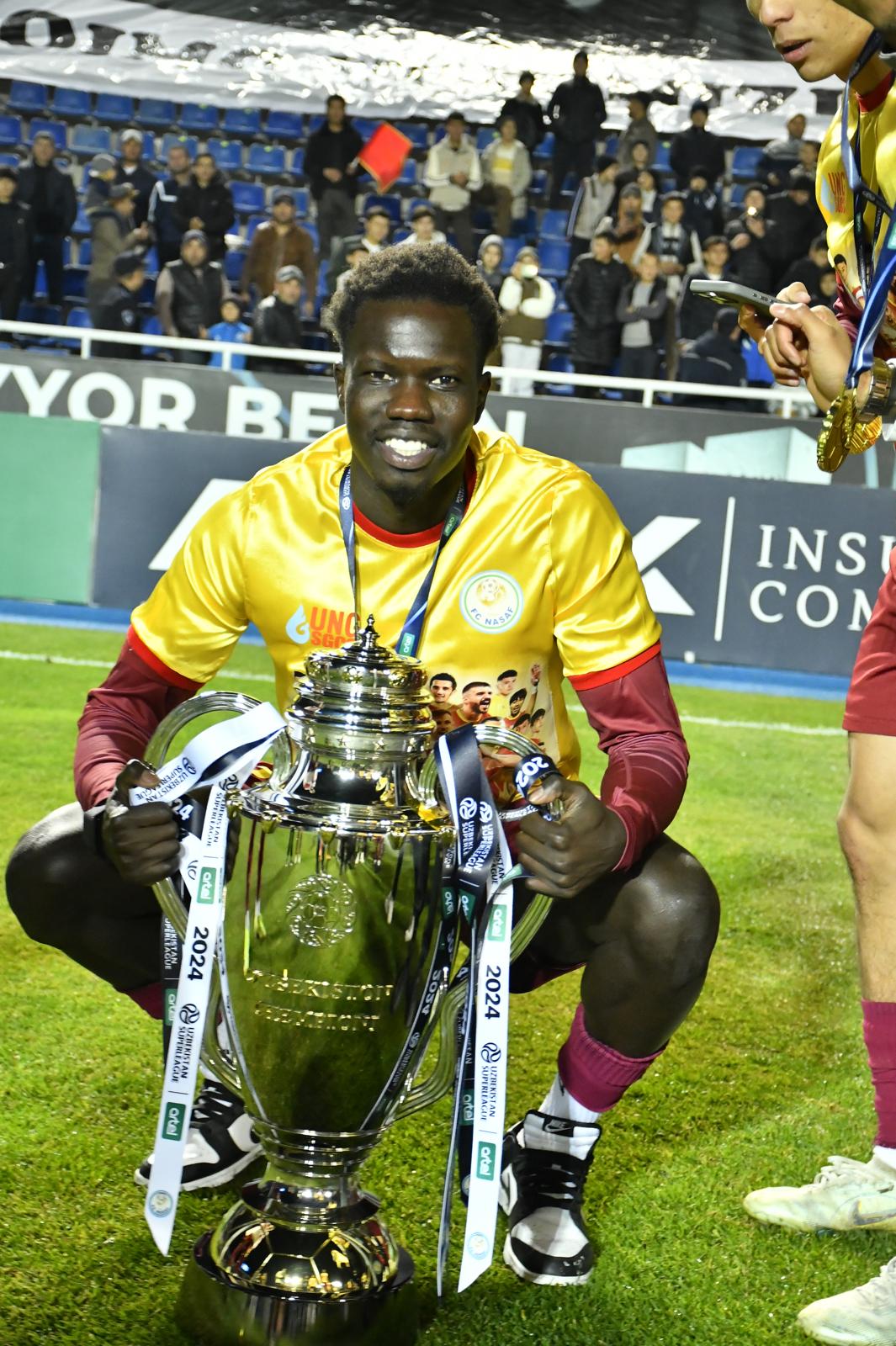 Valentino Yuel poses with the trophy after winning the Uzbekistan Super League