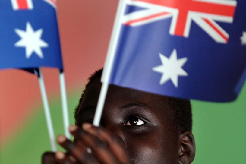 Malek Mawut plays with some Australian flags (AAP: Paul Miller)