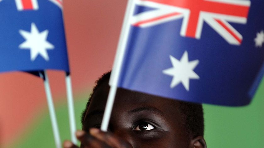 Malek Mawut plays with some Australian flags (AAP: Paul Miller)