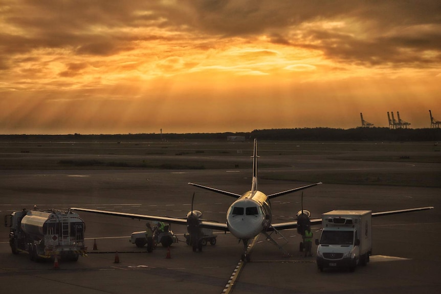 A REX Regional Express Aircraft before flight at sunset at Brisbane Domestic Terminal.