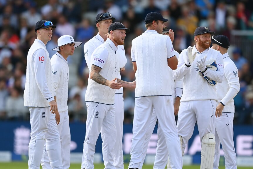 Ben Stokes holds out his hands in a huddle
