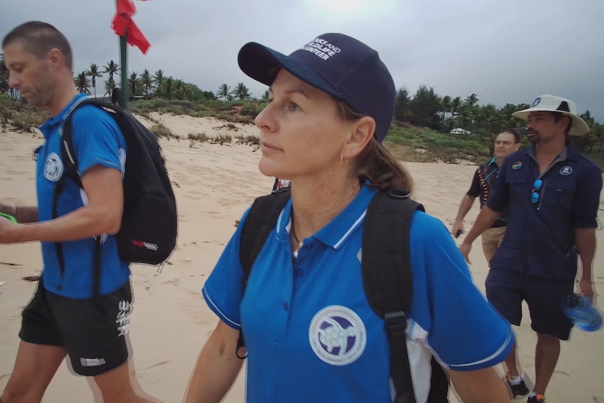 a teacher with some students on a beach