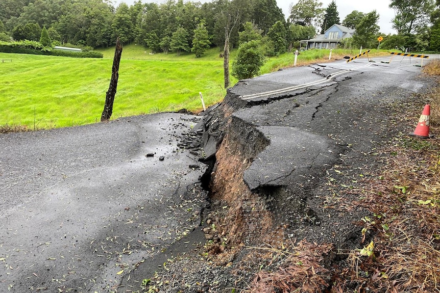 An asphalt road with a major crack after a land slide.