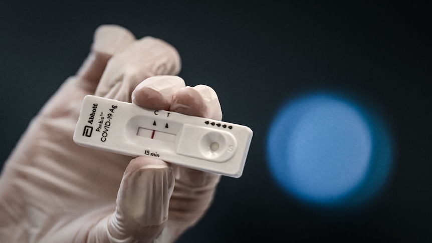 A medical personnel holds a new rapid-result Covid-19 antigen test.