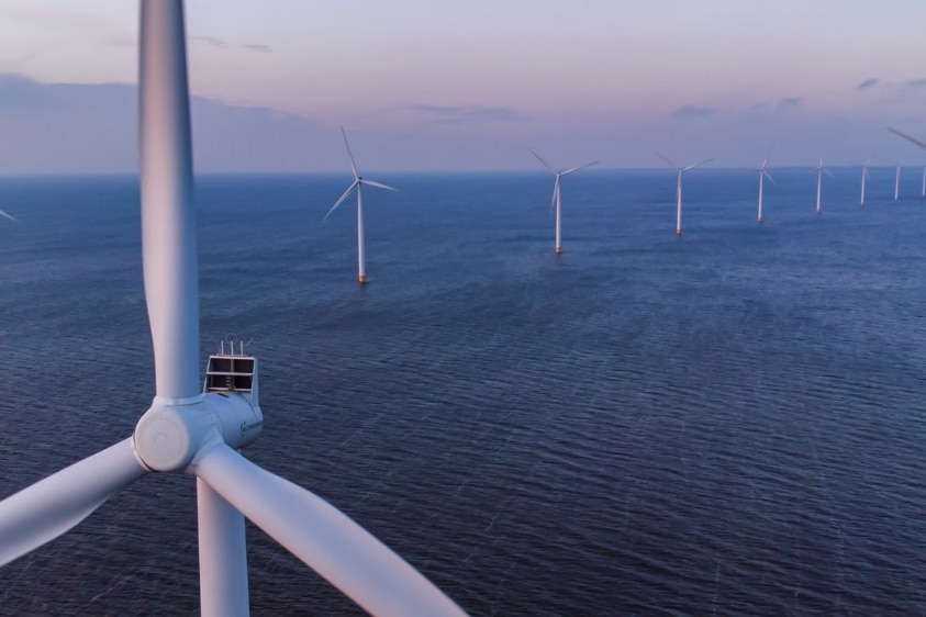 An aerial shot of gigantic wind turbines in the oaceam