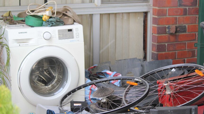 A washing machine and bike, in a yard.