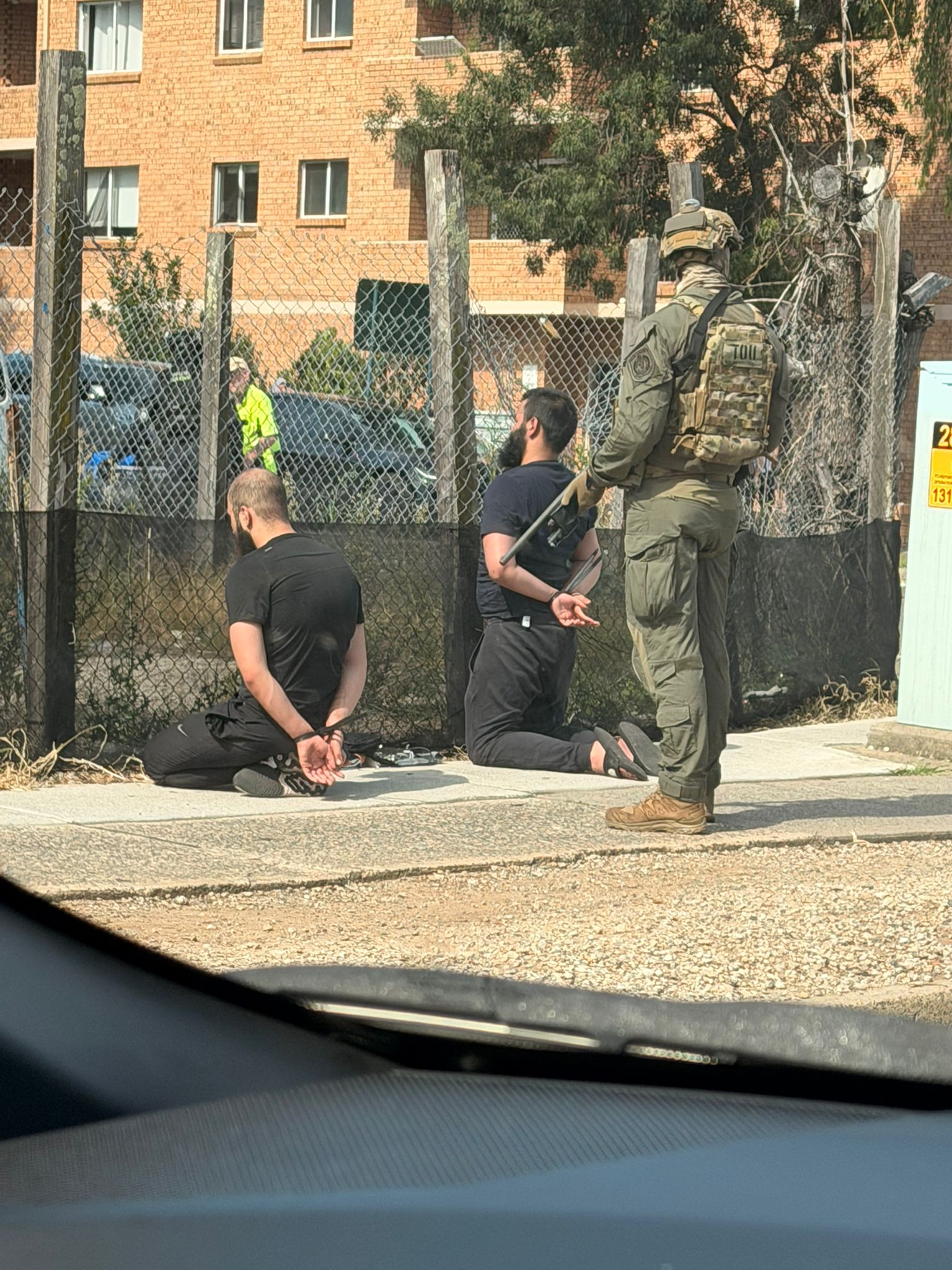 Two men on the ground after being arrested.