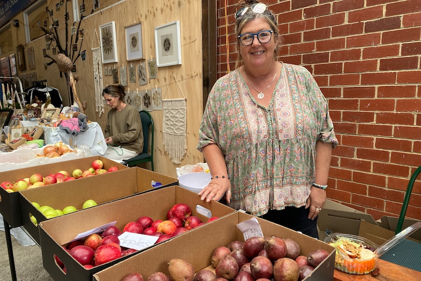 A woman at a market stall selling fruit.