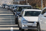 A long line of cars in a turn-off lane.