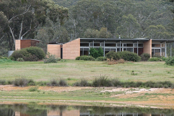 A house with large windows set among the bush and the grassland