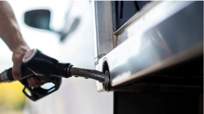 Person holding a fuel pump and filling car with petrol