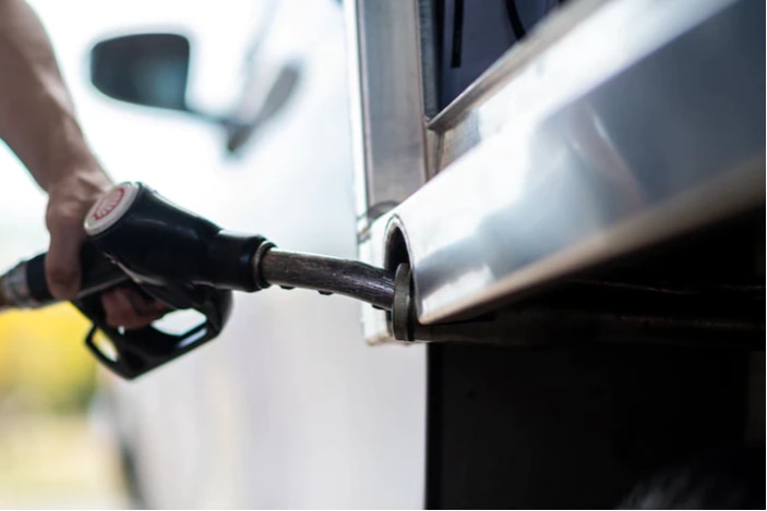 Person holding a fuel pump and filling car with petrol