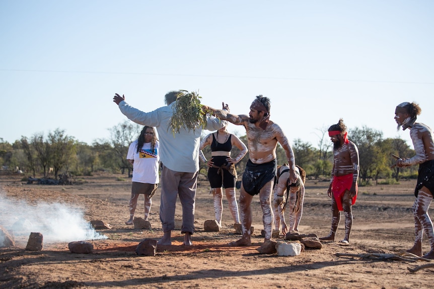 a group of people in a stone circle during a smoking ceremony