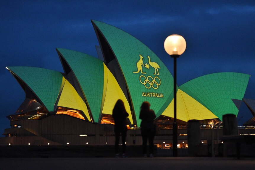 The Sydney Opera House is illuminated with the green and gold