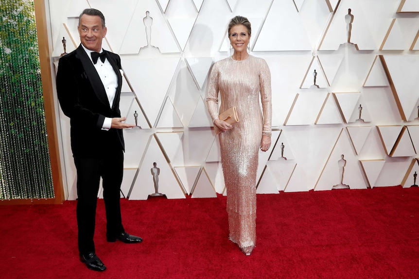 Tom Hanks points at his wife Rita Wilson on a red carpet