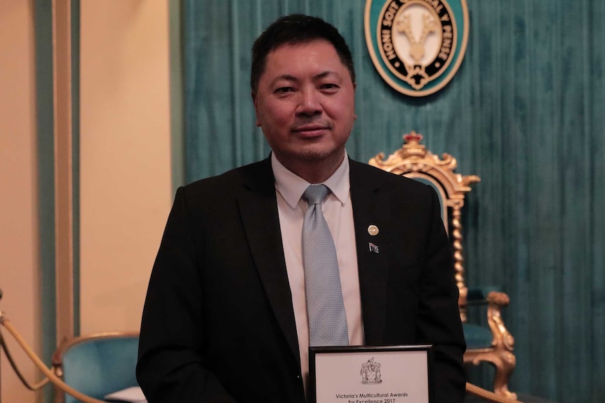 Mr Tan is pictured at the Victorian Multicultural Excellence Awards in 2017, holding his award.