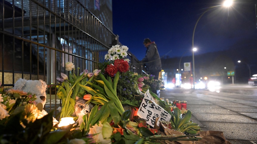 Flowers lay on the side of the road to mourn the lives from a shooting in Hamburg.