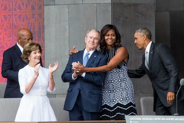 Michelle Obama hugs George W. Bush at the Smithsonian National Museum of African American History and Culture.