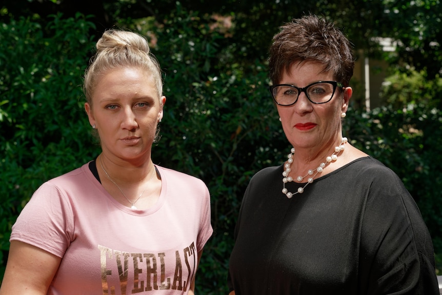 Young woman standing next to her former high school principal.