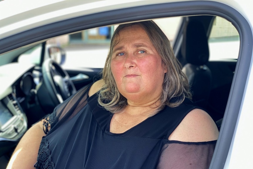 A woman sits in a car