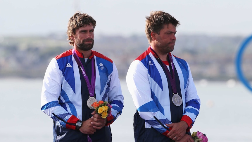Andrew Simpson (R), on the medal podium at the London Olympics, died following a training accident in San Francisco
