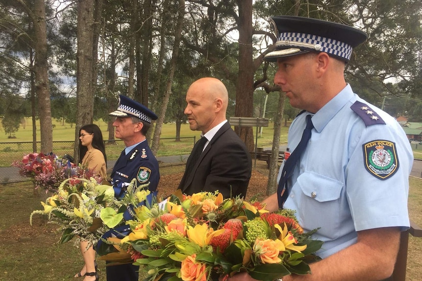 Police, including Commissioner Andrew Scipione, hold wreaths of flowers at the Bowraville memorial.