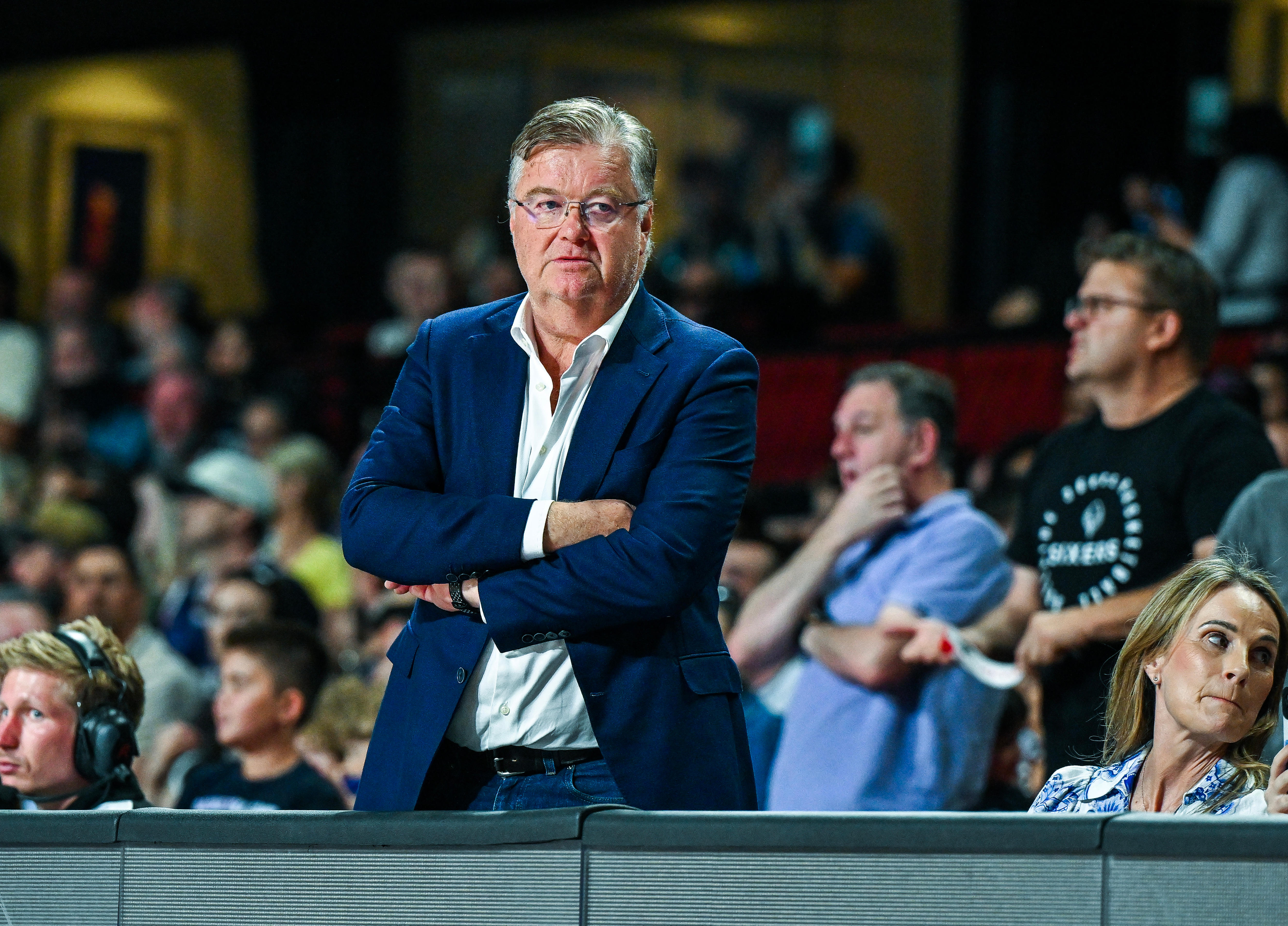 Grant Kelley crosses his arms while wearing a suit