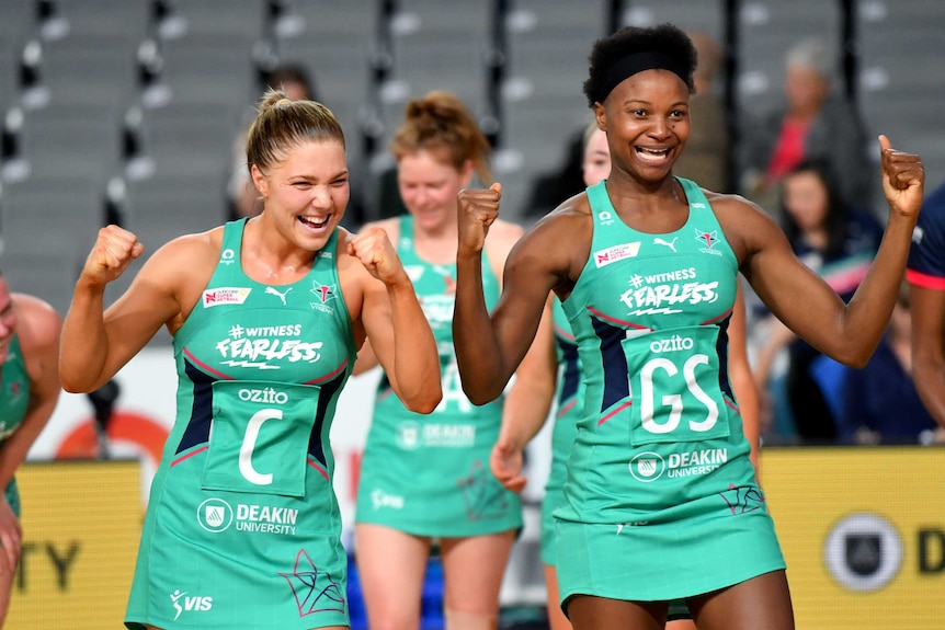 Two Melbourne Vixens Super Netball players pump their fists as they celebrate a win over Collingwood Magpies.