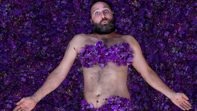 Scott Collins lying in a bed of petals.