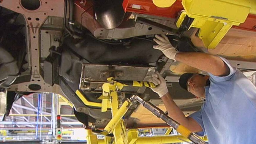 Holden factory worker under car chassis