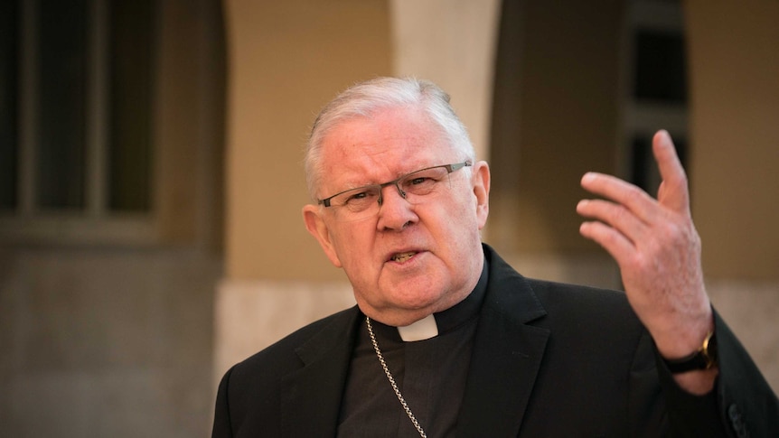 Archbishop of Brisbane Mark Coleridge gestures with his hand while taking questions about child abuse in the Catholic church