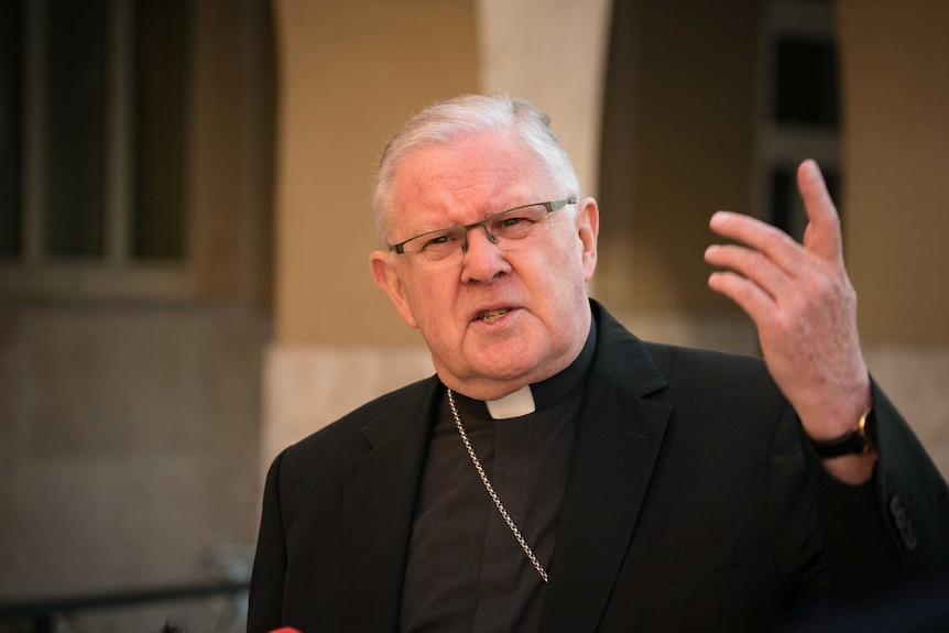 Archbishop of Brisbane Mark Coleridge gestures with his hand while taking questions about child abuse in the Catholic church