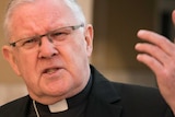 Archbishop of Brisbane Mark Coleridge gestures with his hand while taking questions about child abuse in the Catholic church