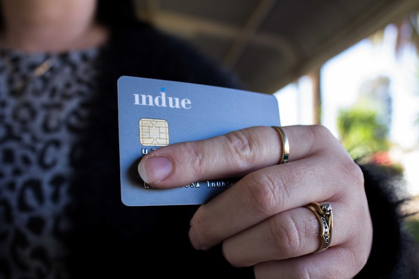 A hand holding an Indue cashless welfare card.