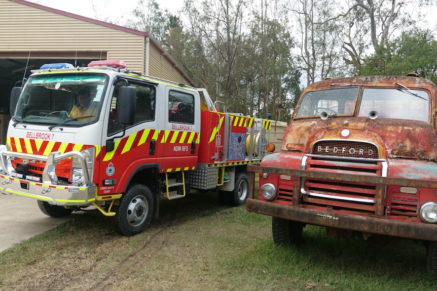 A modern fire truck sitting next to an old rusty fire truck.