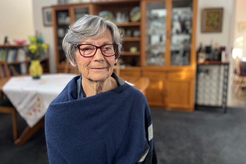An old woman with grey hair and glasses.