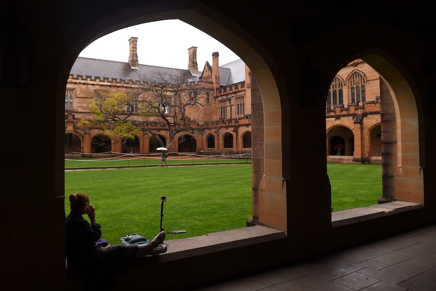 a student sitting outdoors at a university